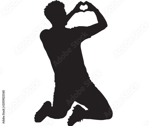 Athlete silhouette makes a heart shape with his hands while kneeling on the ground.