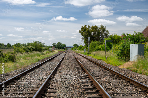 Straight railway track of the Bristol to Birmingham main line under a blue summer sky near Ashchurch, Tewkesbury, Gloucestershire