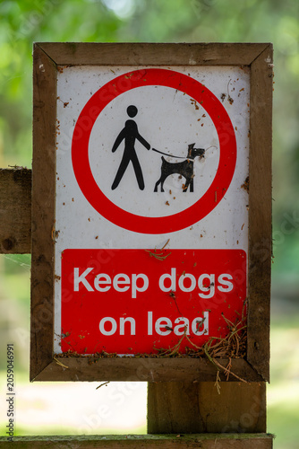 'Keep dogs on lead' red and white sign on a countryside footpath near Ashchurch, Tewkesbury, Gloucestershire