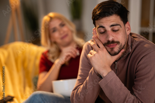 Canvastavla Man sleeping on couch, partner feeling bored