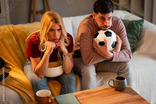 Canvas Print Couple anxiously watching soccer game at home