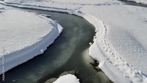Frozen river landscape with snow covered banks.