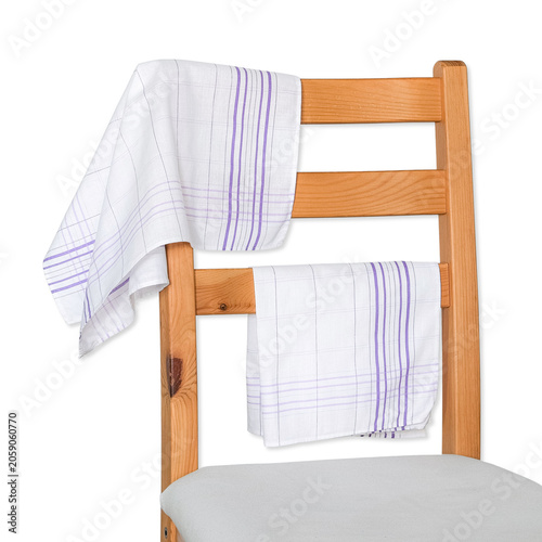 Two white cotton handkerchiefs with a purple striped plaid pattern draped elegantly over the back of a wooden chair.