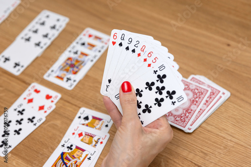 Woman's hands holding a fan of playing cards — card game, leisure, entertainment