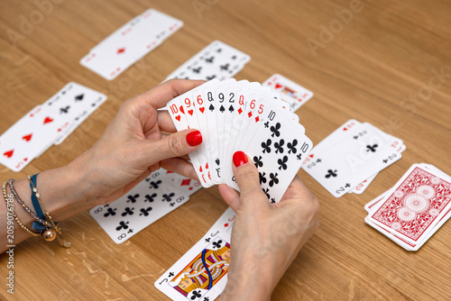 Woman's hands holding a fan of playing cards — card game, leisure, entertainment
