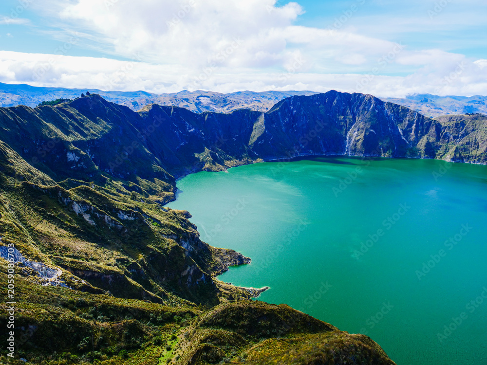 Obraz premium Breathtaking aerial view of the turquoise Quilotoa volcanic crater lake nestled within the dramatic mountainous landscape of the Ecuadorian Andes