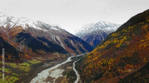 Aerial panoramic valley with braided river and snowcapped peaks, vibrant autumn palette and sweeping horizon ideal for travel marketing, adventure tourism and scenic destination storytelling