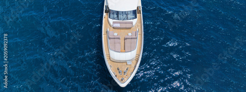 Aerial drone photo with copy space of luxury yacht with wooden deck cruising in high speed deep blue Aegean sea