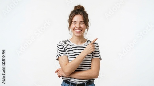 Smiling woman pointing at copy space in striped shirt against white background for commercial advertising