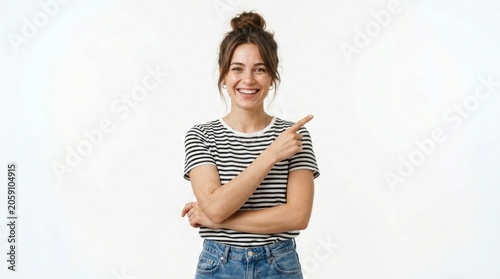 Smiling woman pointing finger aside in striped shirt on white backdrop with sharp studio focus for commercial advertising