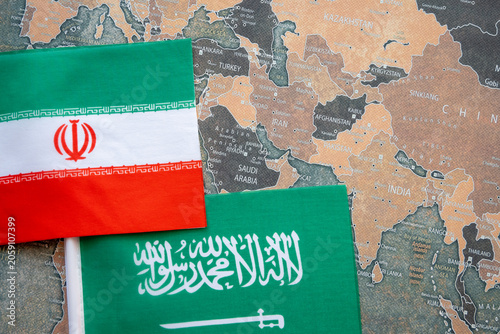 Iran and Saudi Arabia national flags on the paper world map. Iran and USA war.