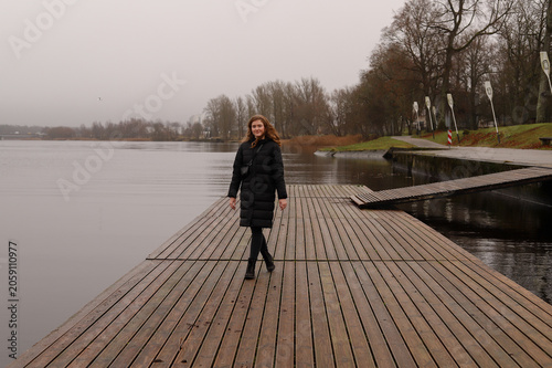A lonely walk along a wooden pier by a calm lake in autumn