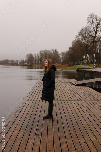 A lonely walk along a wooden pier by a calm lake in autumn