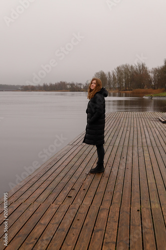 A lonely walk along a wooden pier by a calm lake in autumn