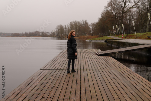 A lonely walk along a wooden pier by a calm lake in autumn