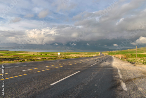 Empty rural highway with stormy sky and open landscape