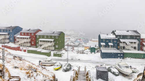 Photography Colorful Greenlandic houses during heavy snowfall with snowy road, wooden stairw