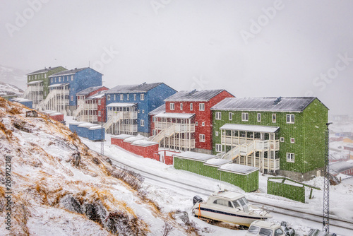 Photography Colorful Greenlandic houses during heavy snowfall with snowy road, wooden stairw