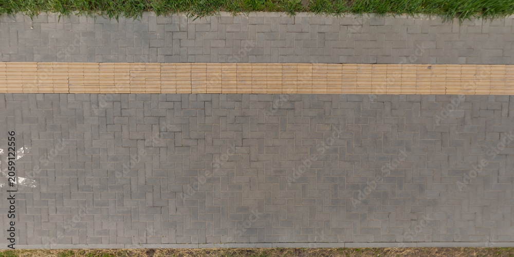 Fototapeta premium top view of surface of pedestrian path with paving slabs with the border of light and shadow