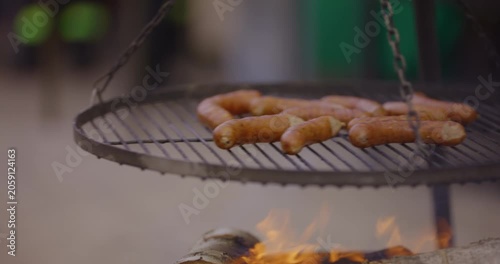 Grilled sausages cooking on a barbecue rack