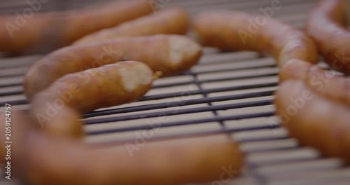 Grilled sausages cooking on a barbecue rack