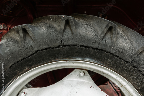 Worn and cracked tire detail on vehicle wheel.