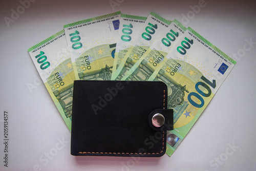 Obraz na płótnie Stylish men's wallet lies on paper money with a denomination of 100 euros on a white background