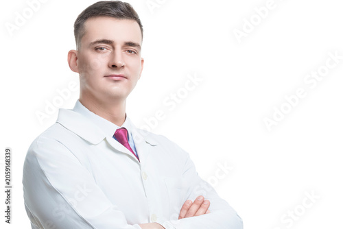 One Positive Confident Professional Male GP Doctor Posing in Doctor's Smock With Hands Folded in Front of Chest Looking Straight Against Pure White