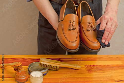 Closeup of Hands of Professional Male Shoes Cleaner with Cleaning Shoe Wax, Cream and Brushes For Tan Calf Leather Tassel Loafers Shoes Working