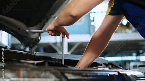 Εκτύπωση καμβά Close-up shot on torque wrench used by certified mechanic in car service to tighten bolts after fixing vehicle parts, repairman utilizing professional tools to repair automobile