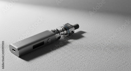 Metallic grey electronic cigarette on textured surface. Close up of modern vape pen with digital screen and glass tank