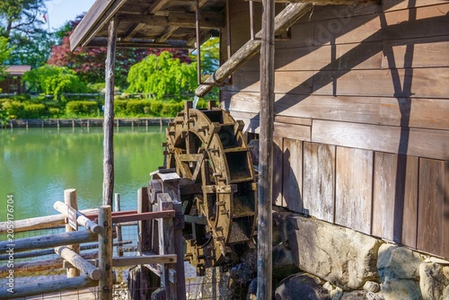 新緑に囲まれた伝統的な日本の水車と水車小屋の美しい風景