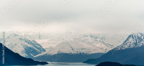 Alaskan Snow-Capped Peaks Under Cloudy Sky