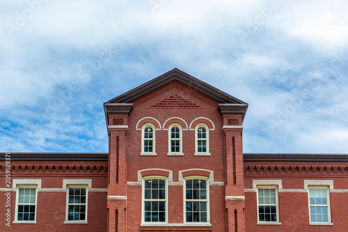Canvastavla Symmetrical facade of a historic red brick building with arched windows and cent