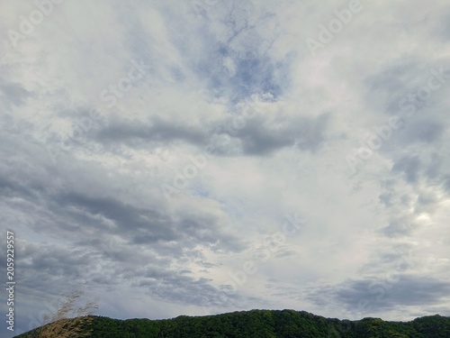 厚い雲が広がる空と丘陵風景 自然のドラマチックな景観
