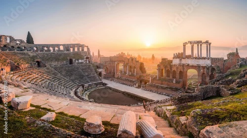 Ancient Roman amphitheater ruins at sunrise with scenic landscape and historic architecture