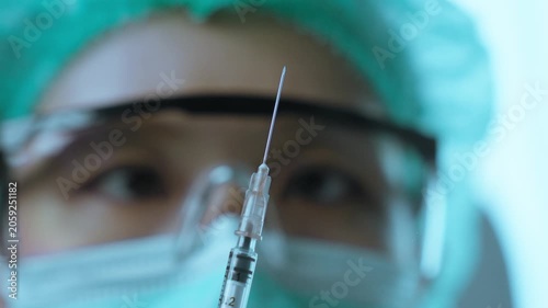 Medical Scientist Inspecting Syringe Before Pharmaceutical Testing Procedure.  Vaccine development, laboratory testing, healthcare safety, pharmaceutical science
