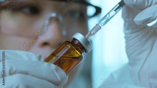 Scientist Injecting Pharmaceutical Liquid into Testing Syringe in Laboratory.  Pharmaceutical laboratory, vaccine research, healthcare testing, scientific innovation
