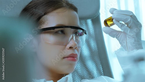 Female Scientist Holding Pharmaceutical Sample for Laboratory Evaluation
