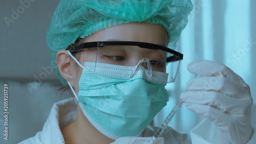 Laboratory Technician Examining Syringe Before Scientific Testing Procedure.  Laboratory safety, pharmaceutical testing, scientific accuracy, healthcare research