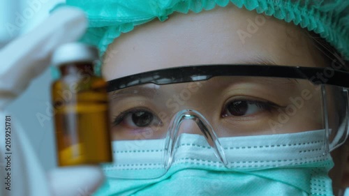 Female Scientist Inspecting Pharmaceutical Vial for Quality Assurance Testing. Quality assurance, pharmaceutical inspection, laboratory testing, healthcare science