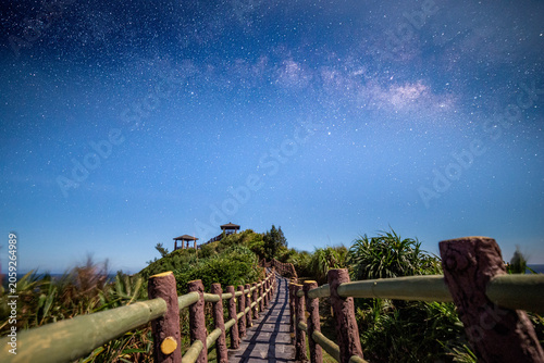 Bild auf Leinwand Scenic path and walking trail on a hill under the beautiful Milky Way galaxy and starry night sky