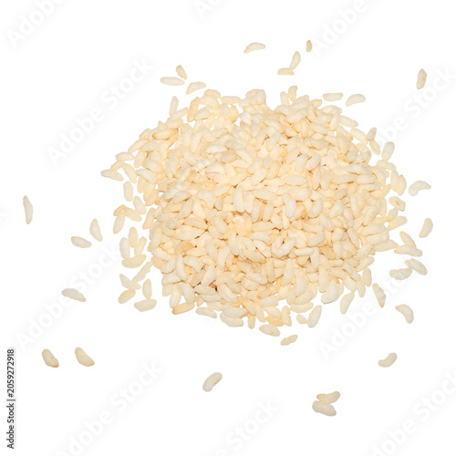 Uncooked Arborio rice kernels scattered on a bright surface during preparation for cooking