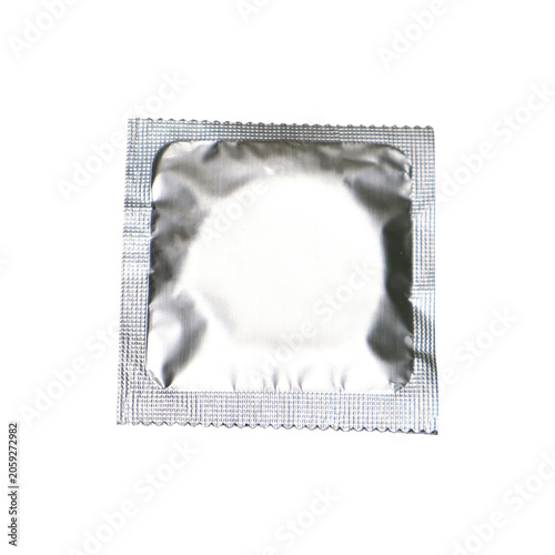 Unwrapped condom in foil packaging against a white surface with soft lighting for health and safety concepts