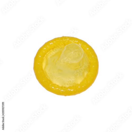 Yellow condom with textured rim laid flat with clear reservoir during studio lighting