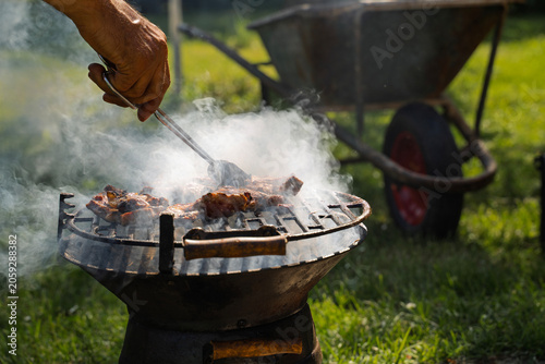 Closeup shot of man preparing barbeque outdoors in the backyard 
