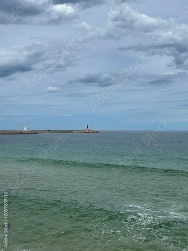 Coastal Lighthouses and Ocean View Under Cloudy Sky