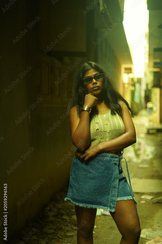 Fototapeta premium Young Woman in Casual Summer Outfit Posing Against Urban Wall