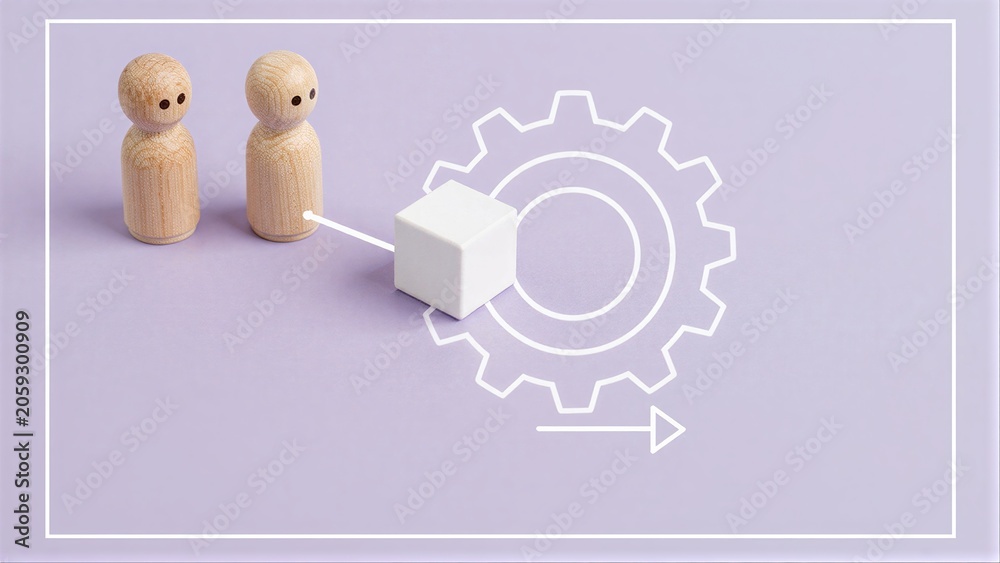 Fototapeta premium Two wooden figures approach a cube, symbolizing teamwork and mechanical process.