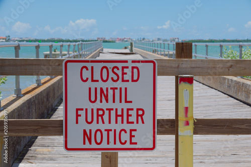 Valokuva Closed Pier Sign on Wooden Boardwalk Dock Over Water at Sunny Marina